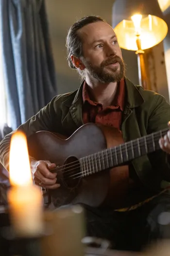 JP Worsfold playing acoustic guitar by candlelight